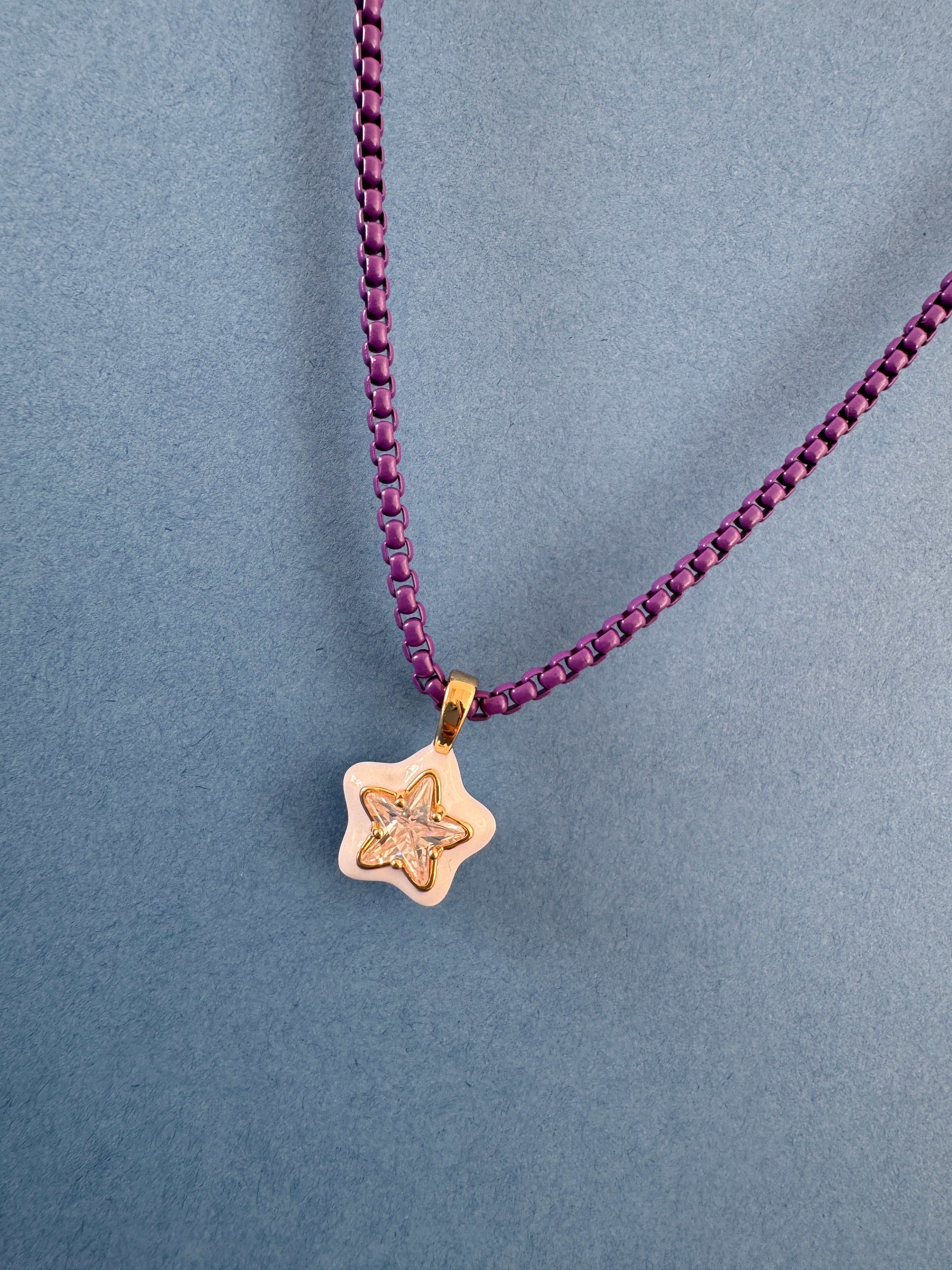 Gold star-shaped pendant on a purple chain
