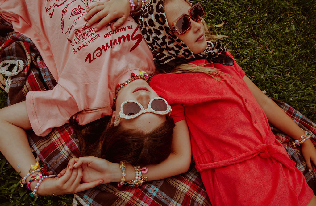 besties holding hands wearing roger charms and accessories.
