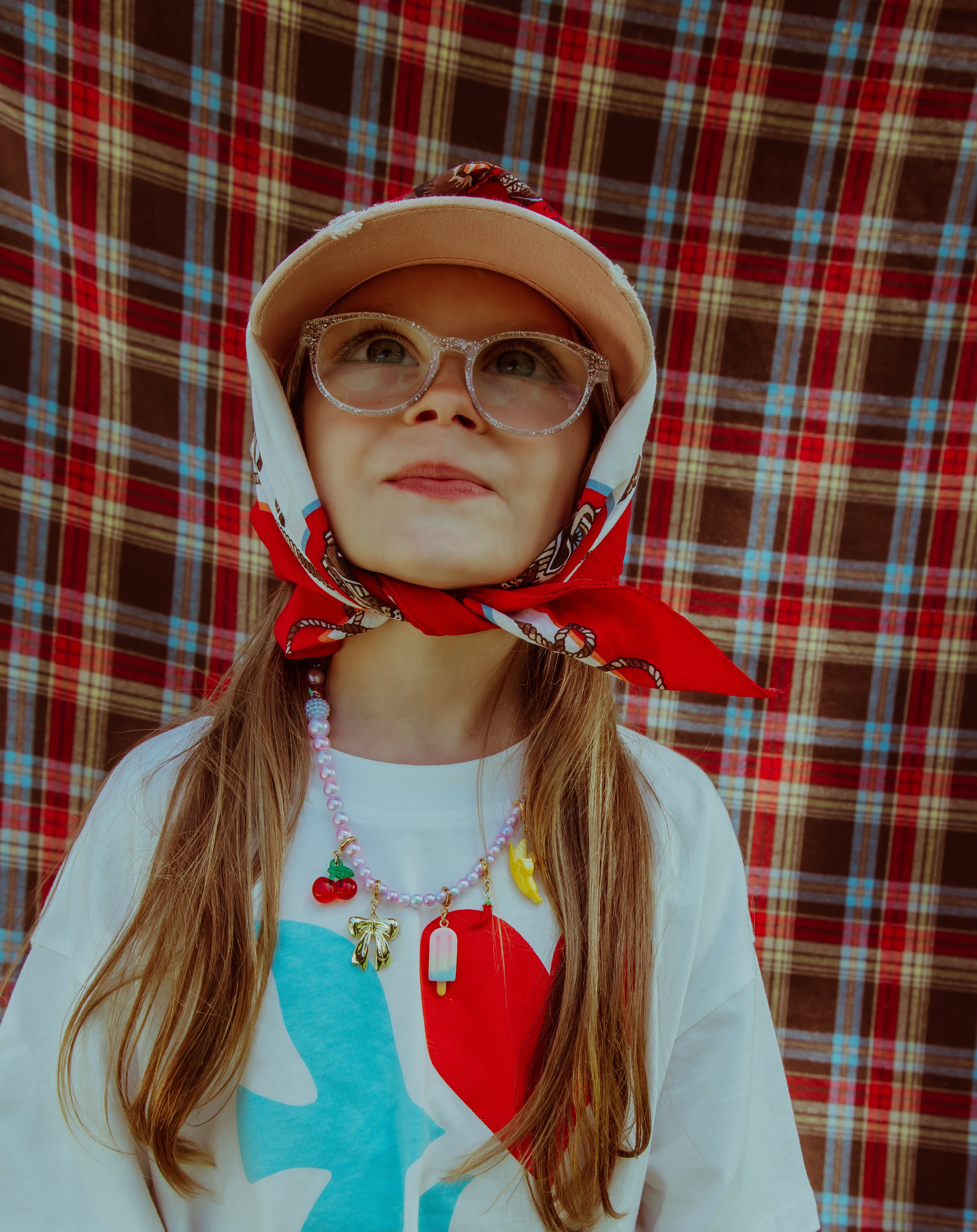 girl wearing scarf and roger official necklace looking up.
