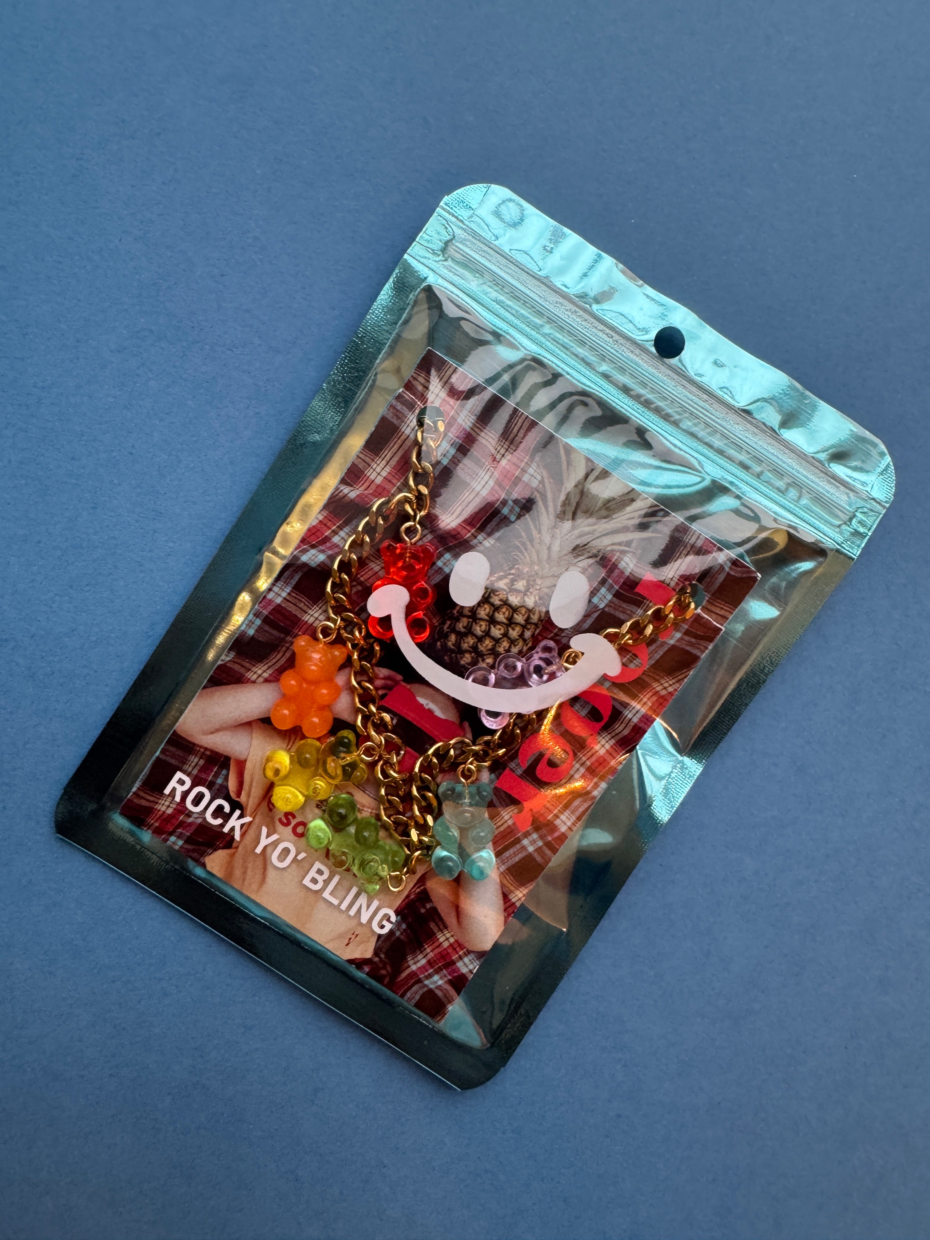 Packaged necklace with colorful gummy bears on a blue background