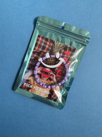Packaged heart bracelet with a colorful label on a blue background