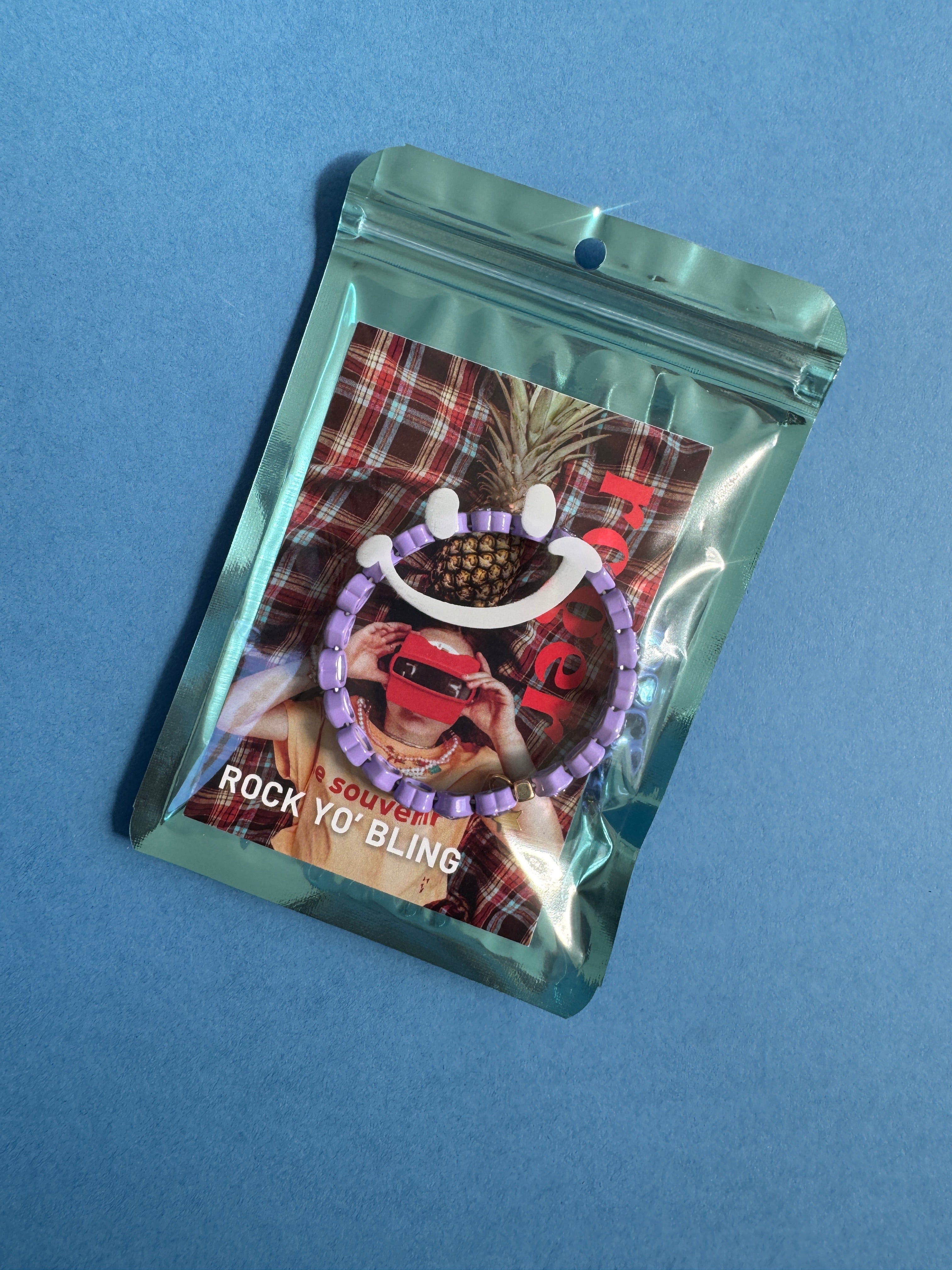 Packaged heart bracelet with a colorful label on a blue background