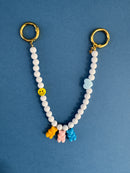 White beaded keychain with colorful charms on a blue background
