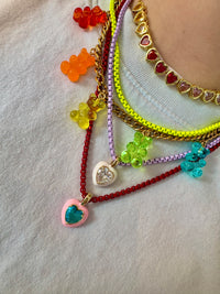 Colorful beaded bracelets with heart charms on a light background