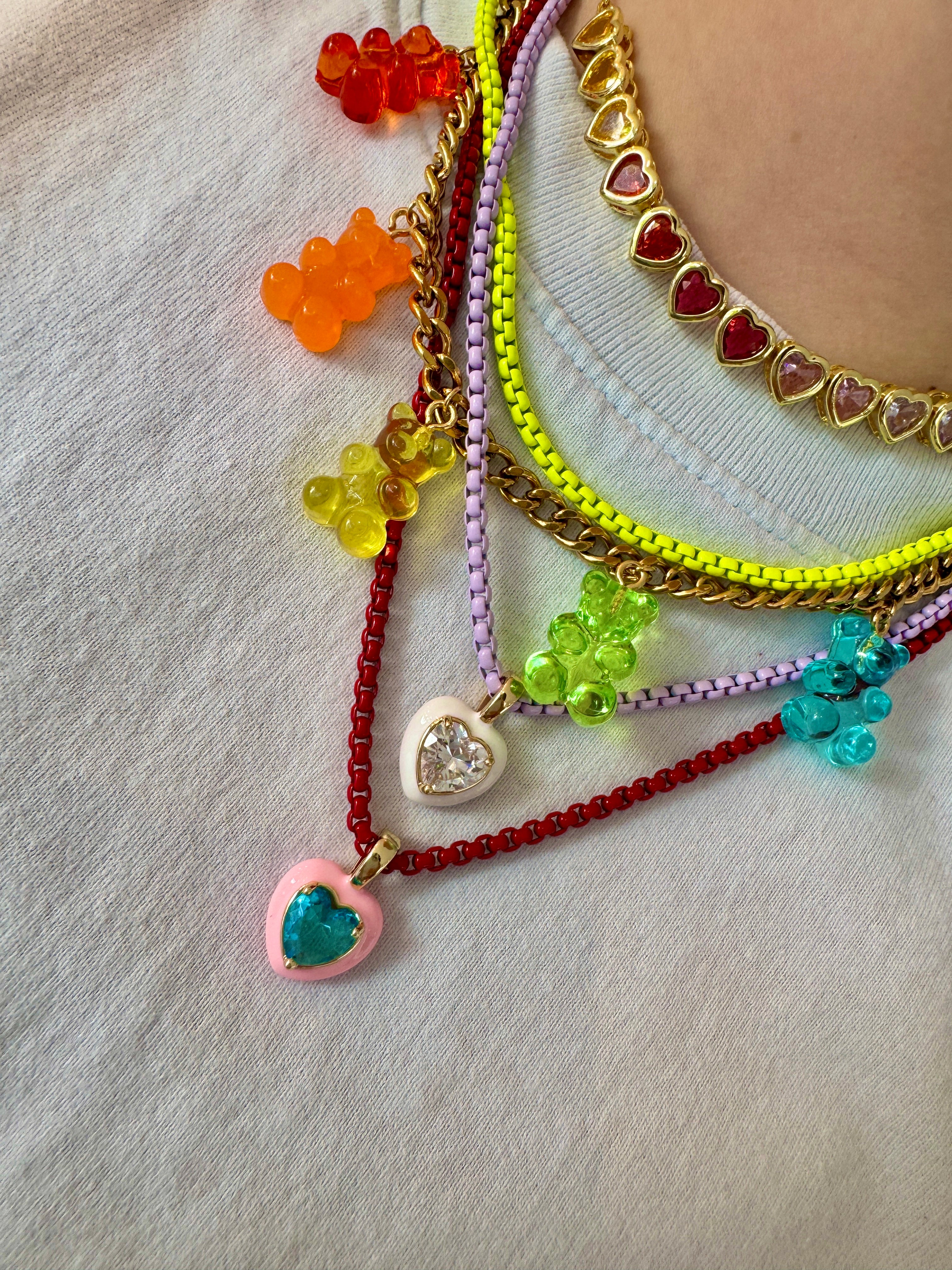 Colorful beaded bracelets with heart charms on a light background