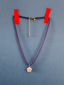 Purple cord with gold clasp and chain on a gray background