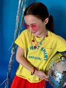 Person wearing a yellow t-shirt with a disco ball against a blue background