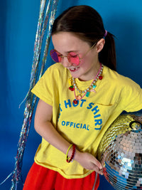 Person wearing a yellow t-shirt with a disco ball against a blue background